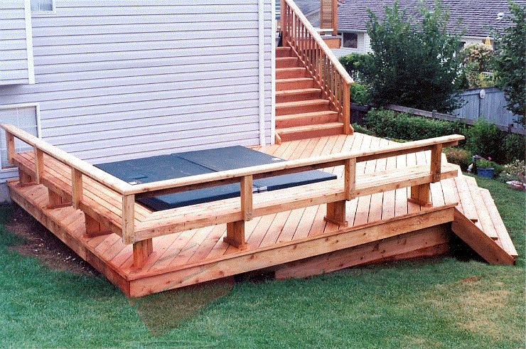 This cedar deck is built on a slope around a sunken hot tub. The deck also features benches along the outer two corners.
