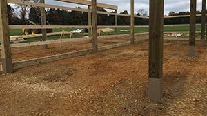 Traditional barn building still uses wood posts set in the ground for the foundation and walls A support post for a barn